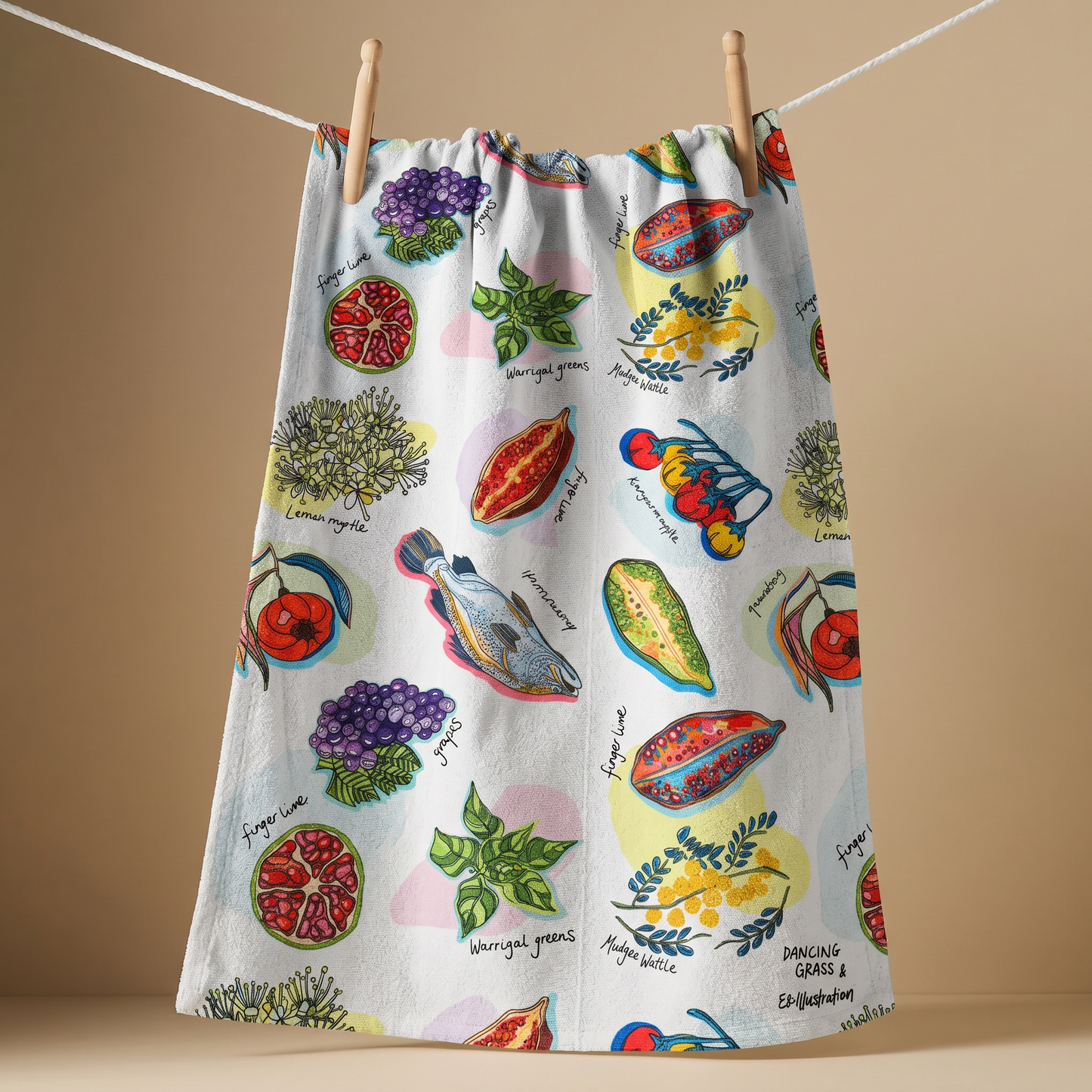 Colorful kitchen towel with bush foods illustrations hanging on a line against a beige background