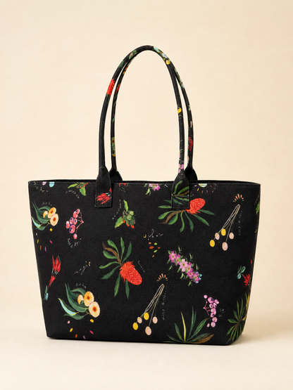 Black tote bag with colorful floral australian patterns on a beige background