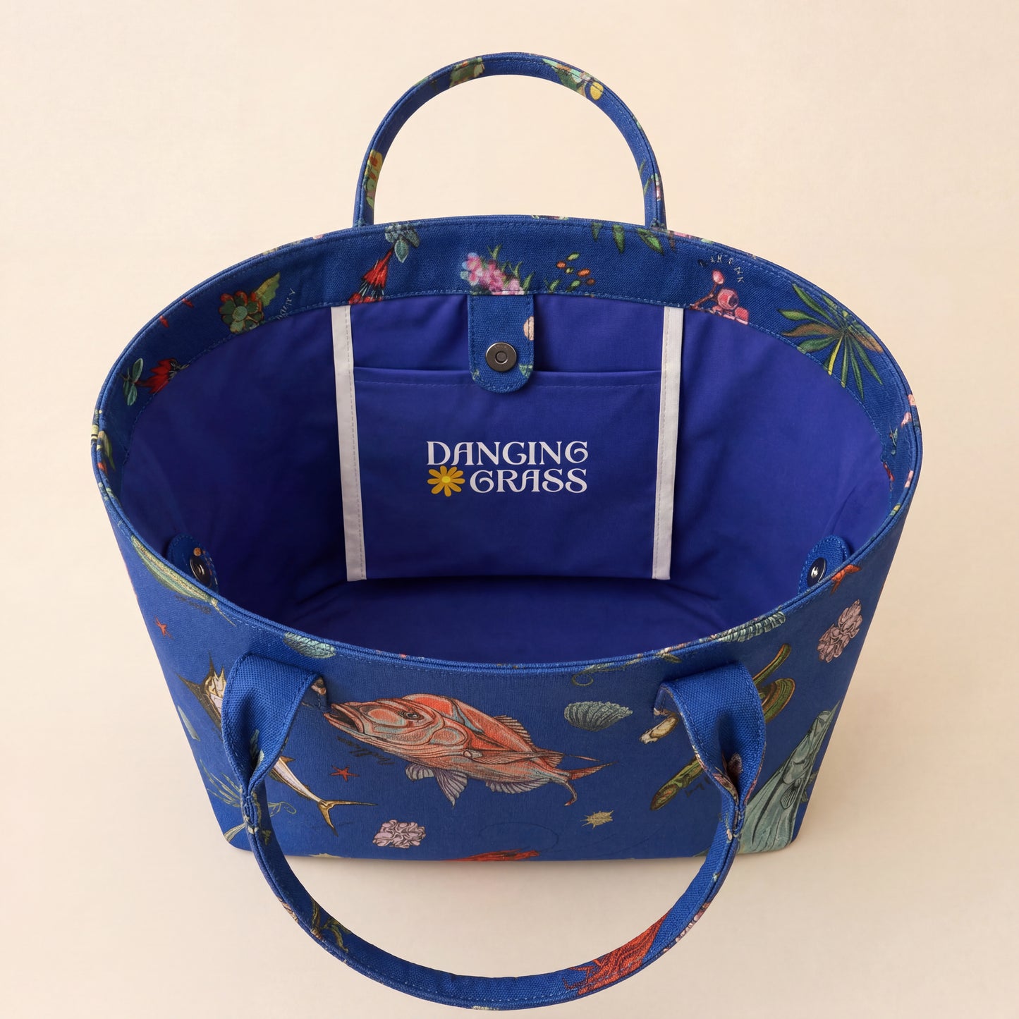 Blue tote bag with australian fish design on a beige background Dancing Grass logo on a beige background