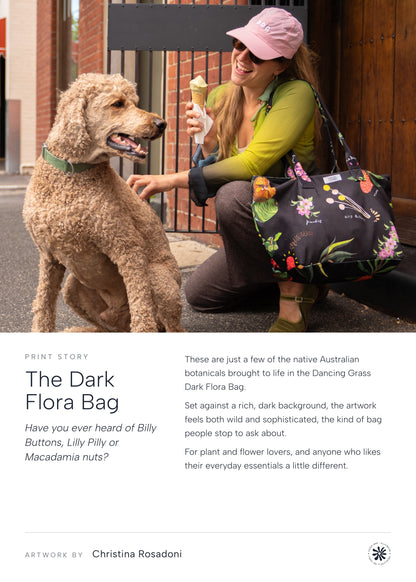 The Dark Flora Bag print story: woman crouching with a dog, carrying the Dark Flora Dancing Grass bag