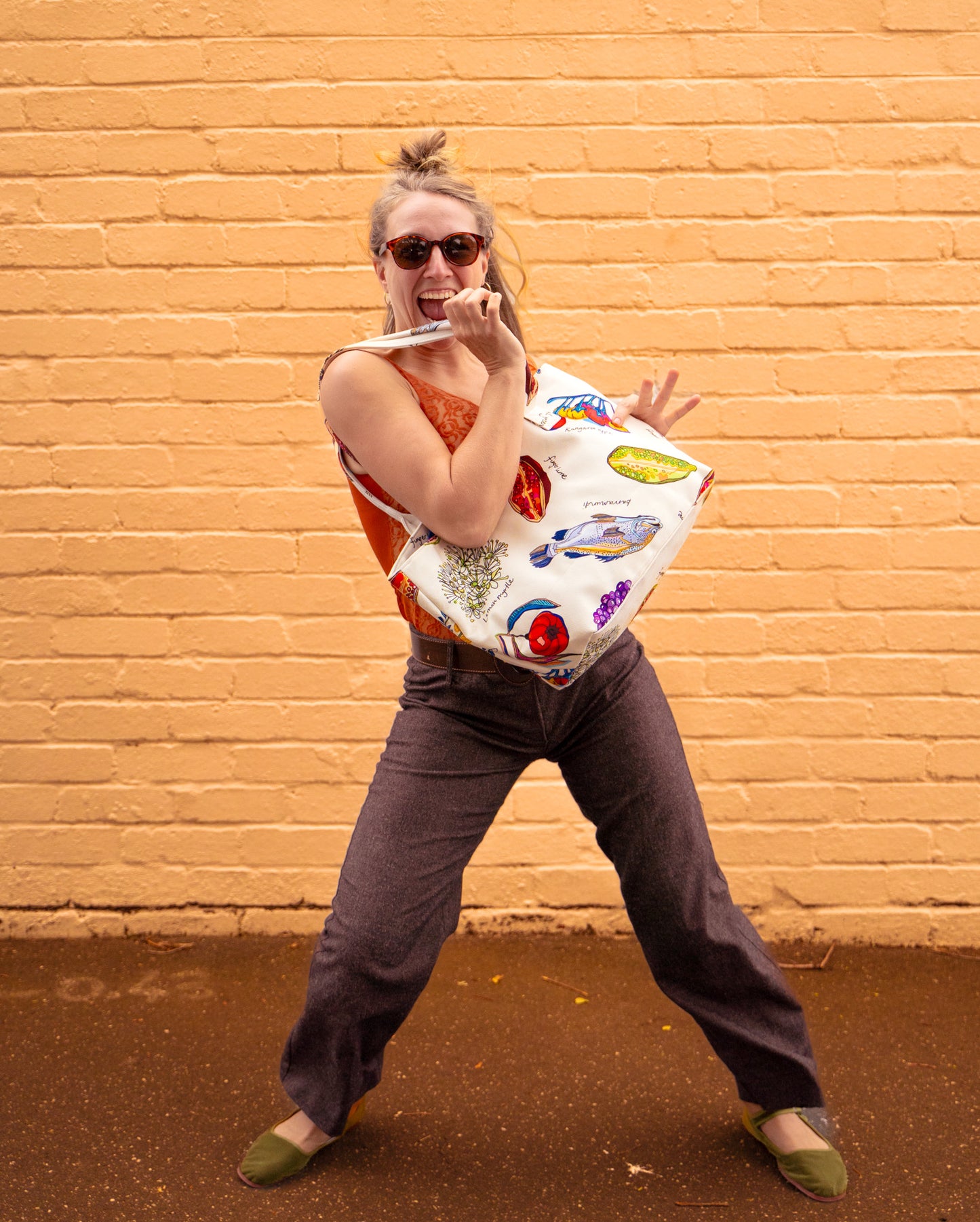 Woman holding the Home Grown colourful structured canvas tote bag featuring Australian native bush food artwork and playful everyday styling