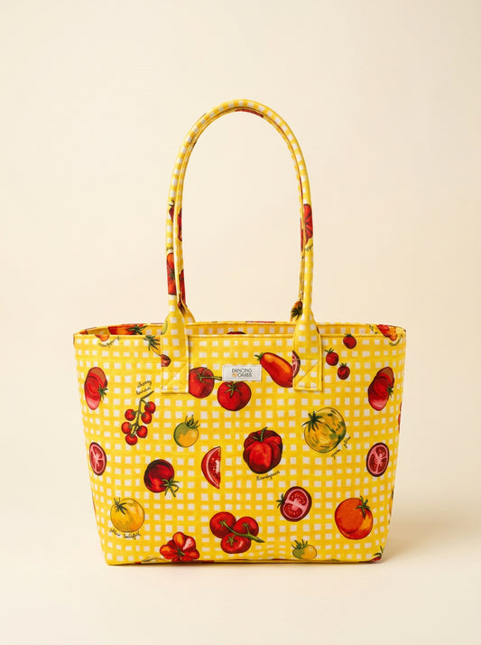 Yellow tote bag with tomato pattern on a beige background